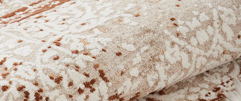 Rolled edge of the Ferro rug in rust and ivory